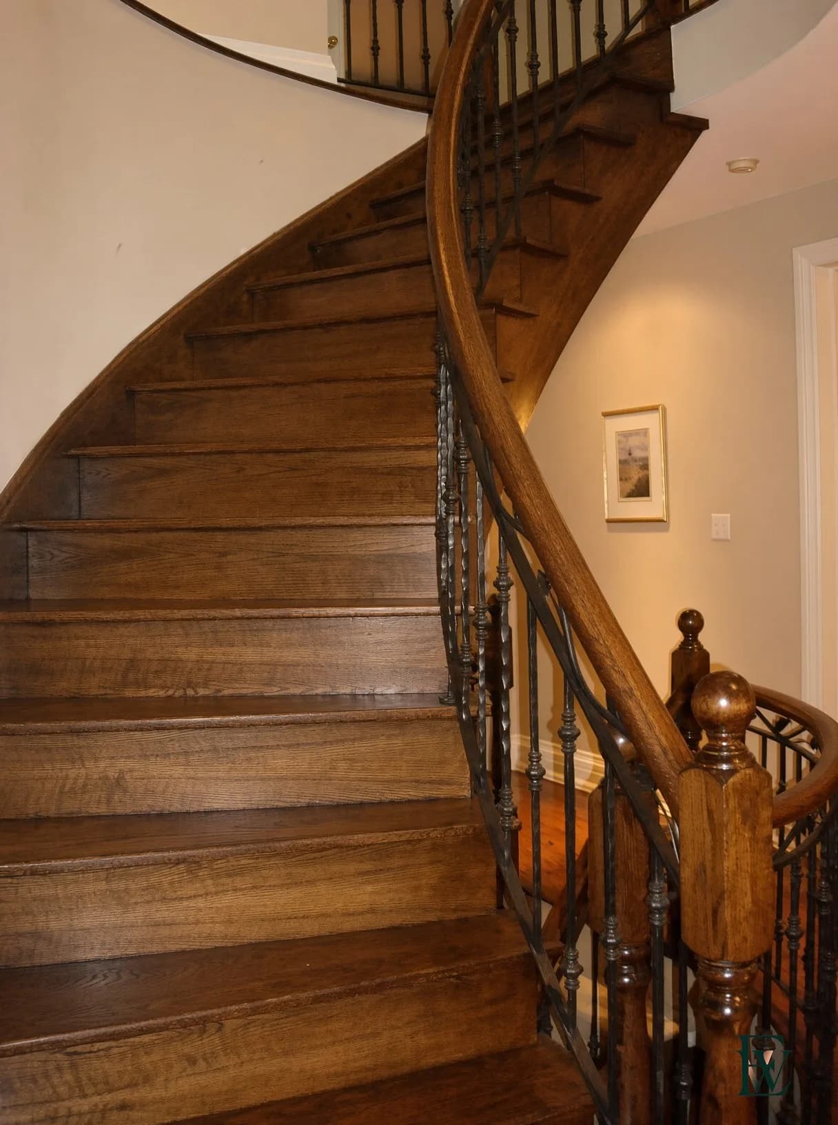 Steam-bent oak handrail curving down a stair flight, frame 1 of 3, full flight view, Ecowoods site work, Toronto.