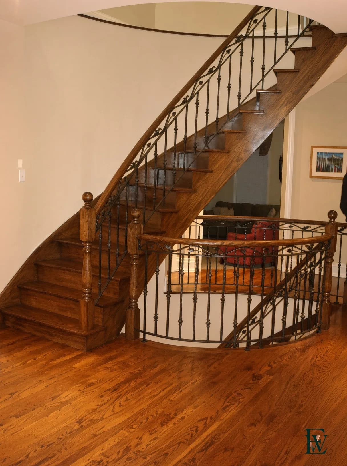 Curved oak stair — The rail starts before the first riser finishes.