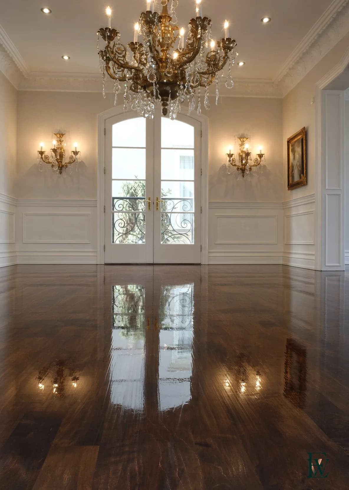 Estate oak · continuous plane — The floor holds the room before the chandelier does.