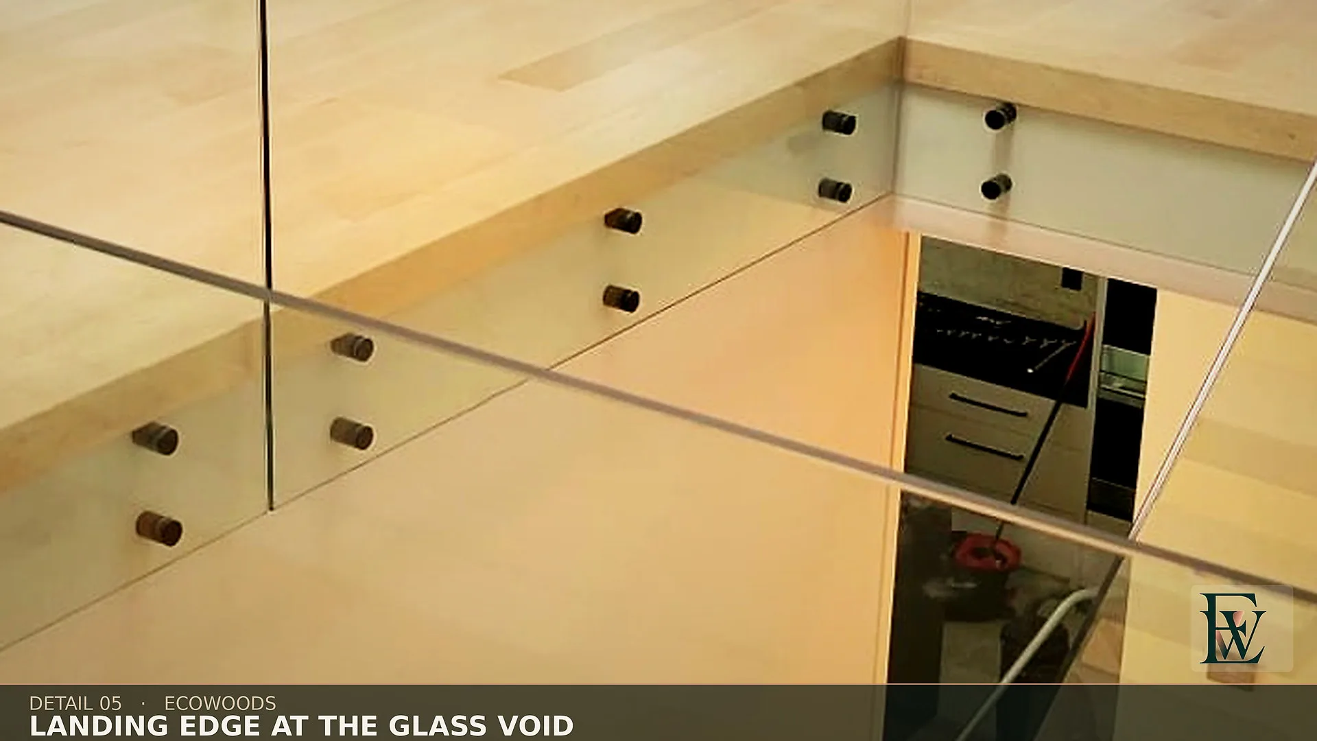 A straight maple edge carried to the glass line where the upper floor breaks into the stair well.