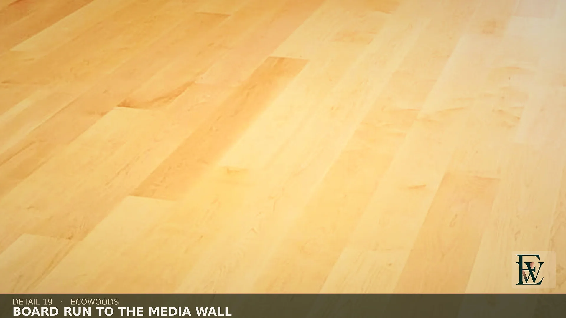 Planks aimed at a walnut media wall, the floor stopping clean at its base.
