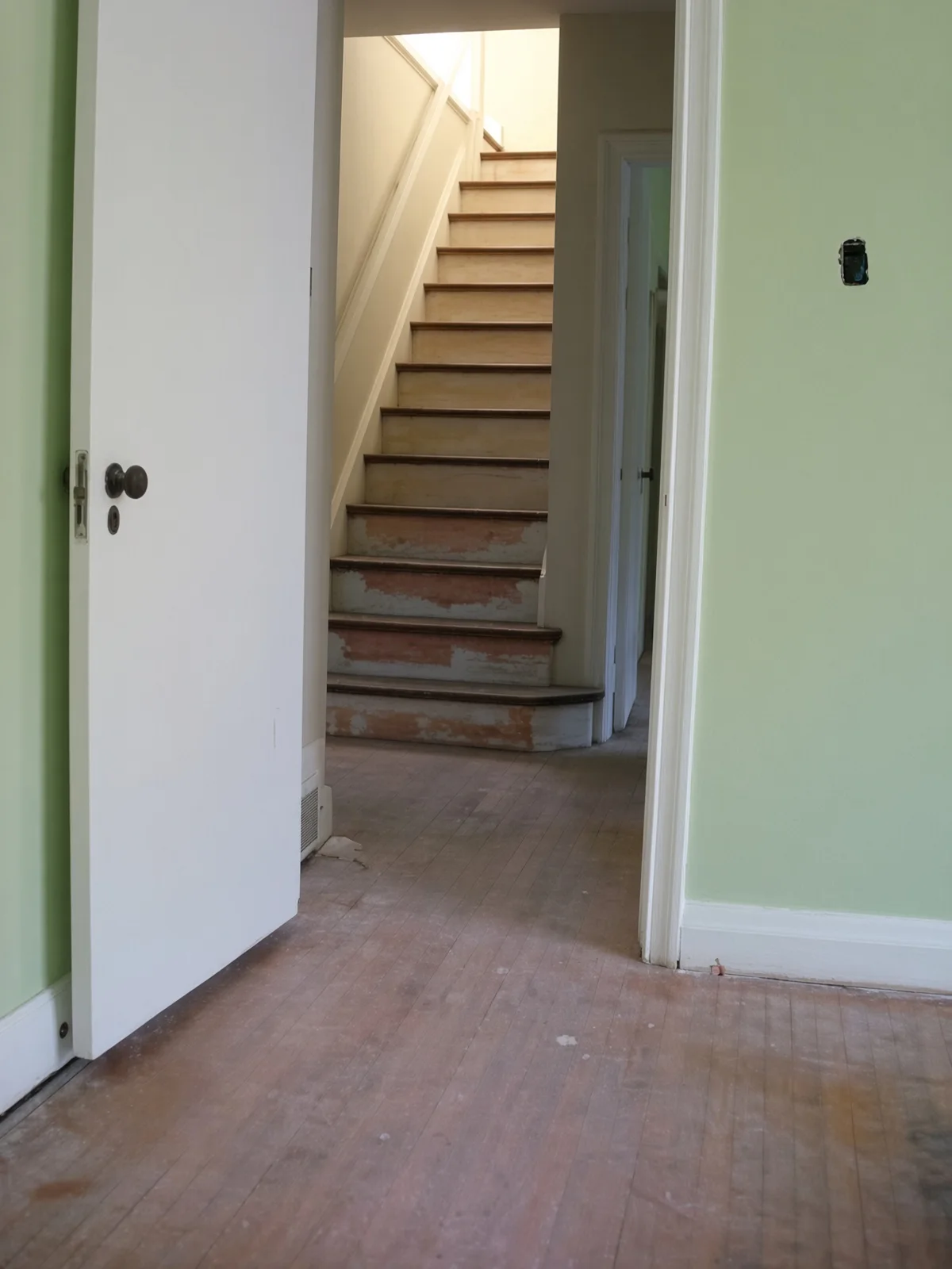 A stair run with paint failing in layers on the risers and treads.