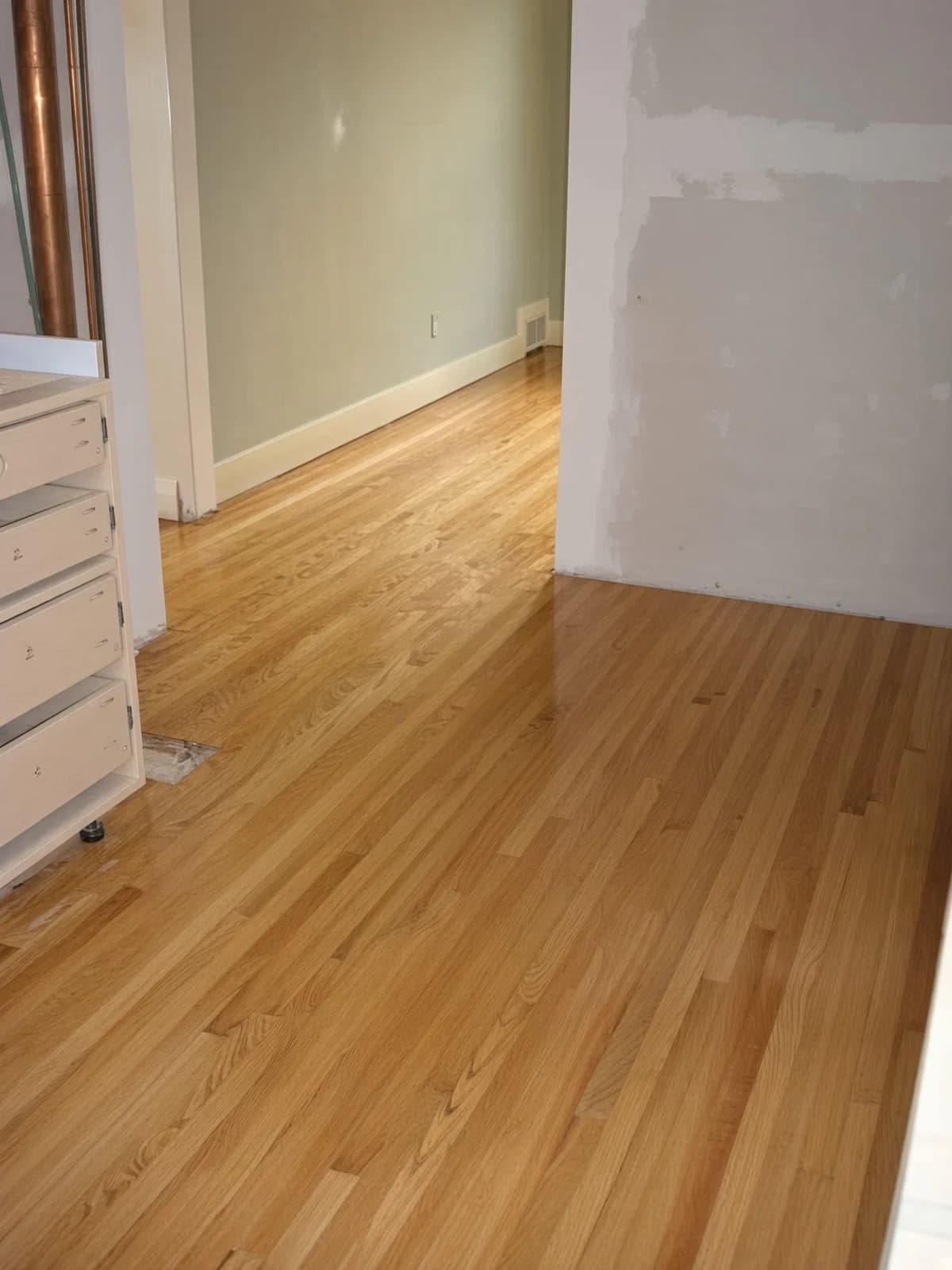 A kitchen threshold with the floor already finished while the kitchen itself is still a shell.